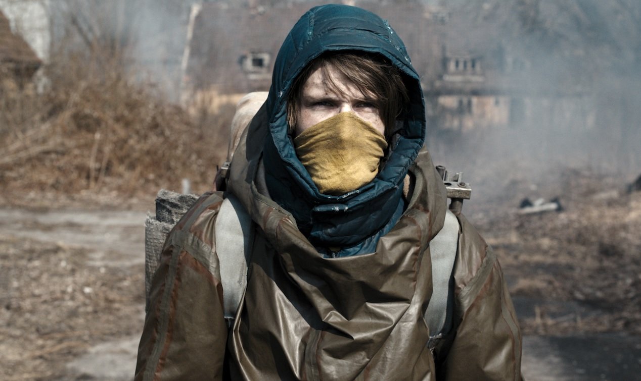 Imagem que mostra um homem barbudo sério e de cachecol